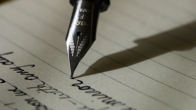 A fountain pen poised to write on paper