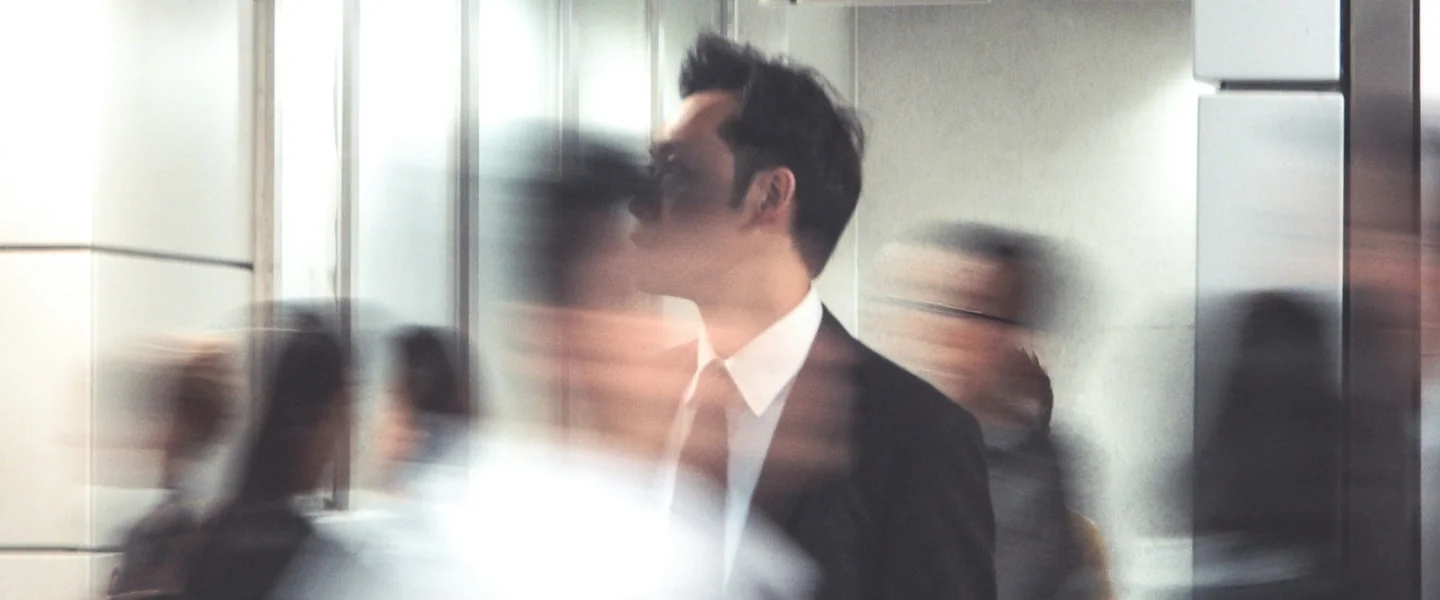 A man in a suit against a blurred crowd